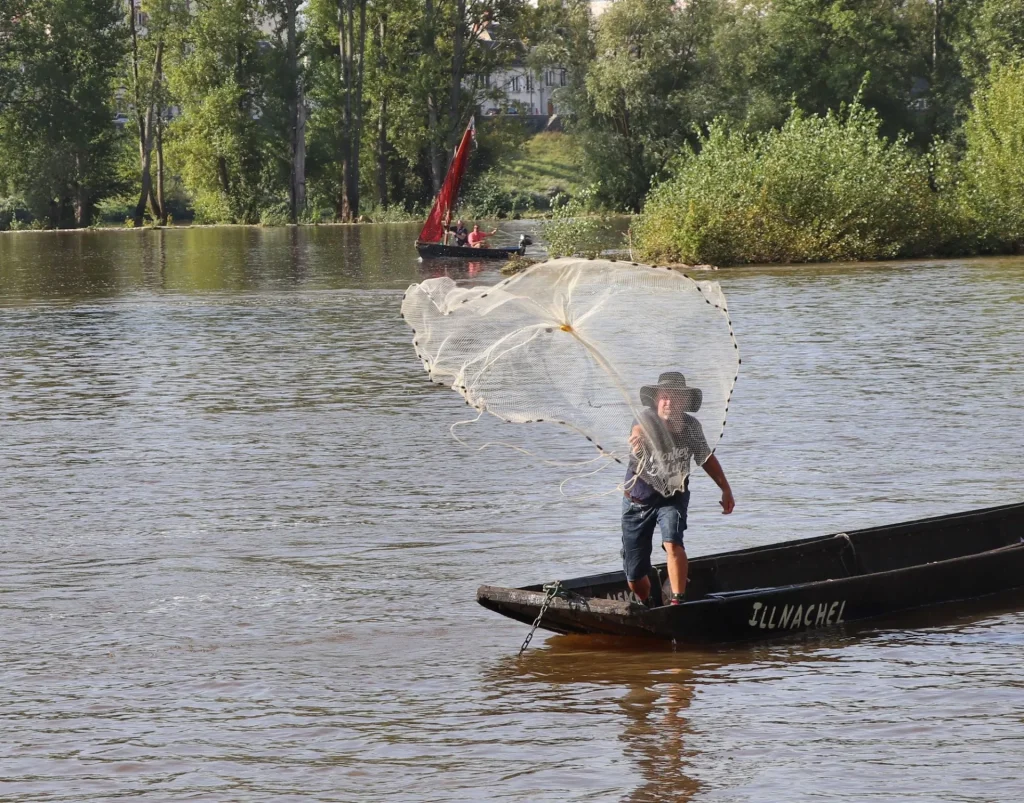 Pêcheur debout sur son bateau lors du Festival de Loire d'Orléans 