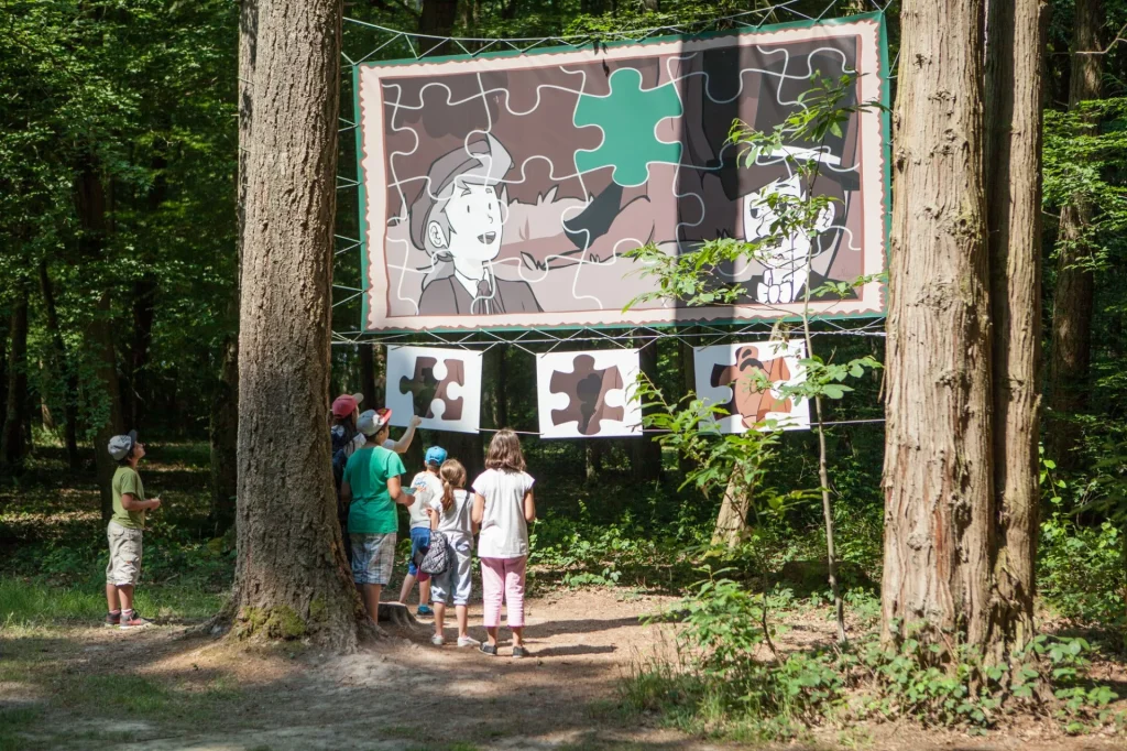 Des enfants devant une affiche en forme de puzzle dans un parc