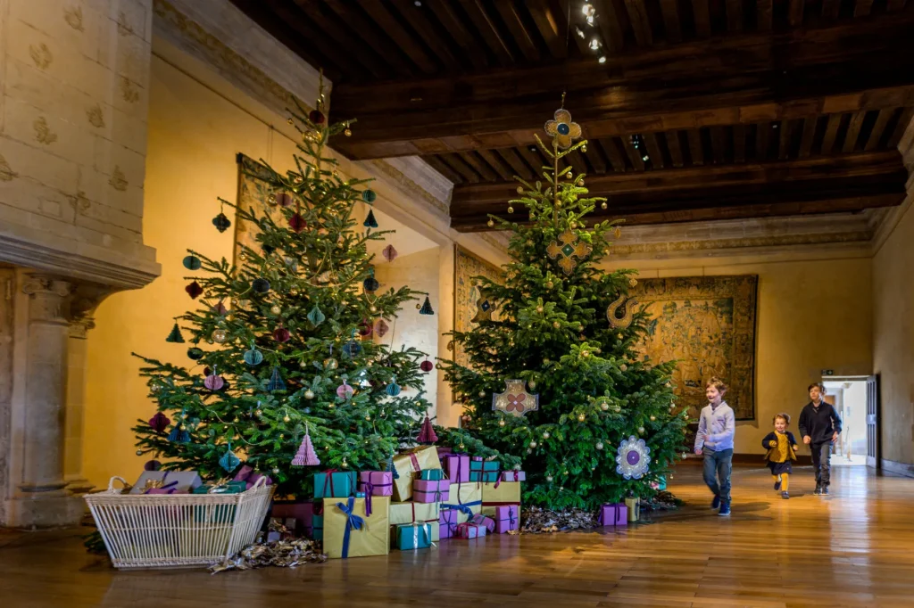 Enfants devant des sapins décorées dans une pièce du château d'Azay-le-Rideau