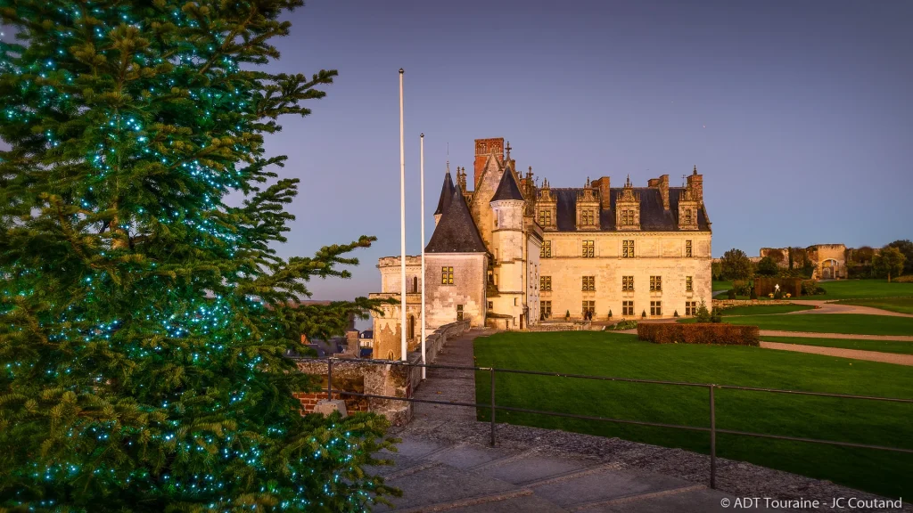 Façade du château royal d'Amboise à Noël avec un sapin décoré en premier plan