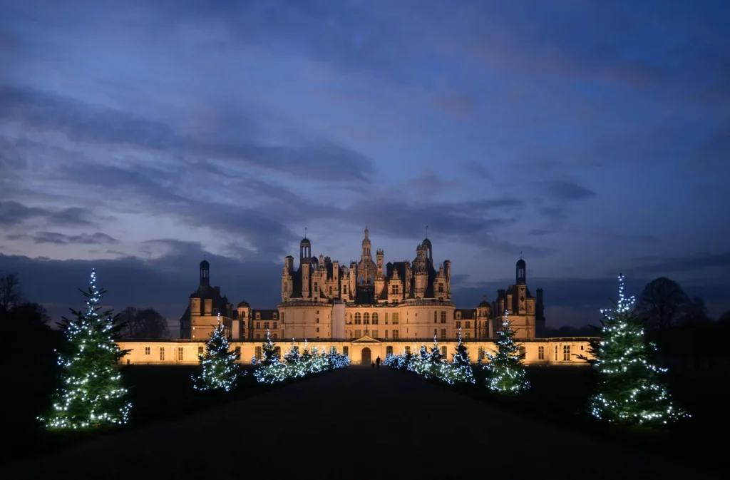 Le château de Chambord de nuit et une allée de sapins illuminés