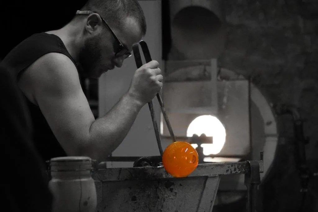 artisan qui manipule du verre chaud