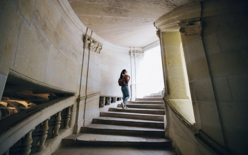 Femme qui monte les escaliers du château de Chambord