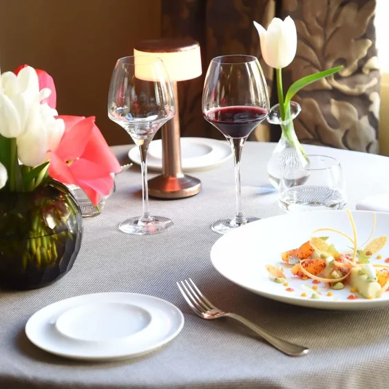 Table dressée avec une assiette contenant une orange sanguine au restaurant du château de Pray